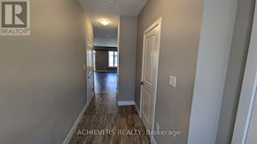 London North (North A) townhouse for rent - A hallway with a door on the right and a window in the distance.