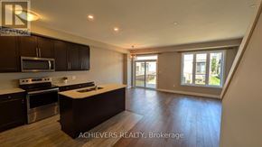 London North (North A) townhouse for rent - A spacious kitchen with dark wood cabinets and stainless steel appliances.