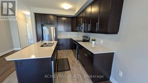 London North (North A) townhouse for rent - A kitchen with Achievers Realty Brokerage logo on the wall.