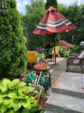 Barrie (Grove East) apartment for rent - A red and white striped umbrella is open over a table with chairs.