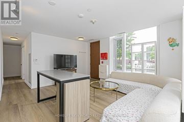 Toronto (Waterfront Communities) townhouse for rent - A living room with a white couch and a television on a black stand.
