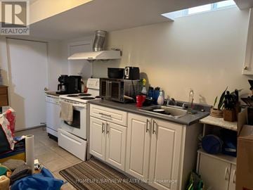 Mississauga (Hurontario) apartment for rent - A kitchen with white cabinets and a black stove top.