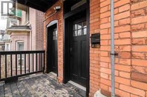 Hamilton apartment for rent - A black door is on the brick wall of a building.