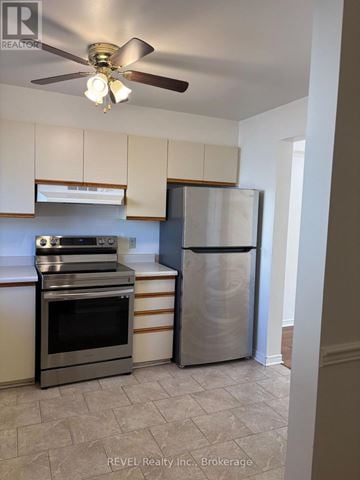 St. Catharines (Carlton/Bunting) townhouse for rent - A kitchen with a stainless steel refrigerator and oven.