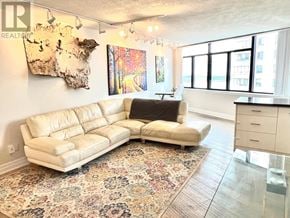 Toronto (Waterfront Communities) condo for rent - A living room with a tan couch and a rug.
