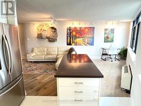 Toronto (Waterfront Communities) condo for rent - A kitchen with a refrigerator on the left and a dining table with chairs in the middle of the room.