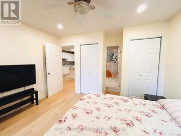 Whitby (Pringle Creek) apartment for rent - A bedroom with a bed, a television, and a ceiling fan.