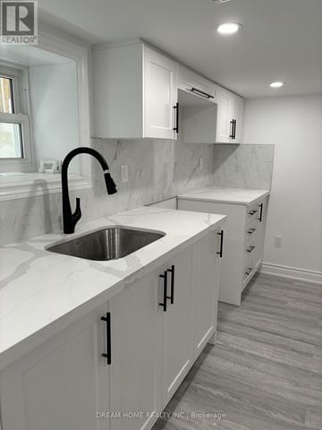 Toronto (Palmerston-Little Italy) apartment for rent - A modern kitchen with white cabinets and a marble countertop.
