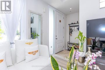 Mississauga (Mineola) townhouse for rent - A living room with a white couch and a large mirror on the wall.