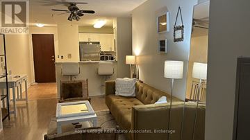 Mississauga (Erin Mills) condo for rent - A living room with a brown couch and a coffee table.