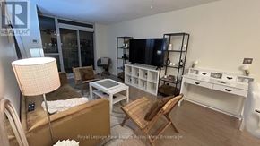 Mississauga (Erin Mills) condo for rent - A living room with a brown couch, a white coffee table, and a TV on a stand.