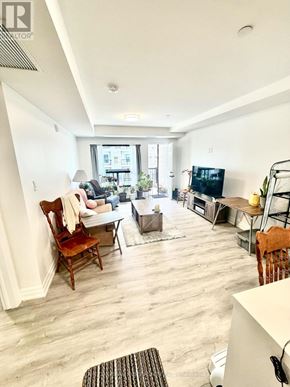 Windsor condo for rent - A living room with a couch, chairs, and a television.