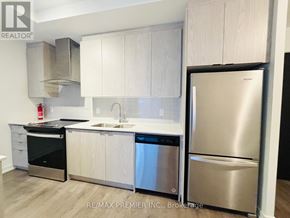 Kitchener condo for rent - A kitchen with white cabinets and stainless steel appliances.