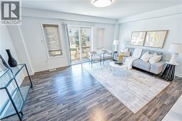 Guelph townhouse for rent - A living room with a white couch and a glass display case.