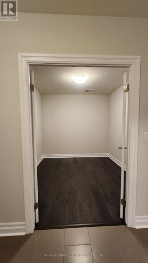London East (East F) condo for rent - A room with a white door and a brown floor.