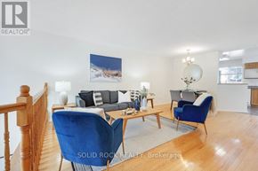 Ottawa townhouse for rent - A living room with blue chairs and a painting of a beach scene on the wall.