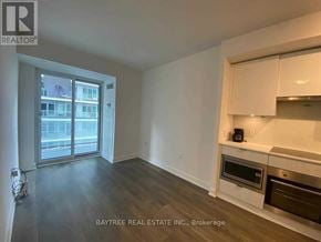 Toronto (Mount Pleasant West) condo for rent - A spacious living room with a kitchenette and a view of the city.