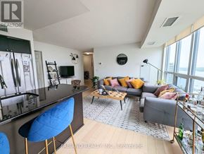 Toronto (Waterfront Communities) condo for rent - A living room with a grey couch and a blue chair.