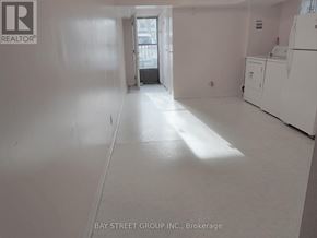Toronto (L'amoreaux) apartment for rent - A white room with a refrigerator and a door leading to another room.