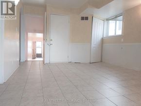 Toronto (L'amoreaux) apartment for rent - A spacious room with white walls and tiled flooring, with a doorway leading to another room.