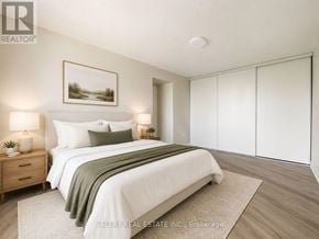Toronto (Crescent Town) condo for rent - A bedroom with a bed, nightstands, and a painting on the wall.