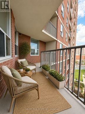 Toronto (Crescent Town) condo for rent - A balcony with a chair and a table with a potted plant on it.