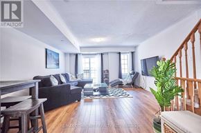 Oshawa (Windfields) townhouse for rent - A living room with a couch, a chair, a coffee table, and a TV.