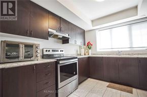 Oshawa (Windfields) townhouse for rent - A kitchen with brown cabinets and a white stove top oven.
