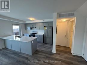 Brampton (Northwest Brampton) townhouse for rent - A kitchen with a refrigerator, stove, and cabinets.