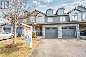 Guelph (Pineridge/Westminster Woods) townhouse for rent - A real estate sign is in front of a large house.