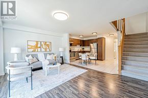 Guelph (Pineridge/Westminster Woods) townhouse for rent - A living room with a white couch, a coffee table, and a painting on the wall.