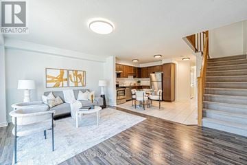 Guelph (Pineridge/Westminster Woods) townhouse for rent - A living room with a white couch, a coffee table, and a painting on the wall.