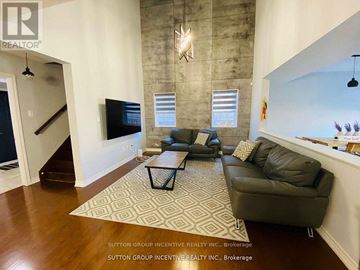 Innisfil (Alcona) apartment for rent - A living room with a black couch and a rug.