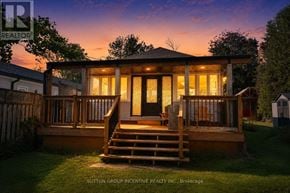 Innisfil apartment for rent - A house with a deck and a sunroom is shown in the image.