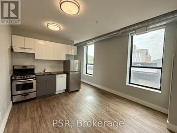 Toronto (Junction Area) condo for rent - A well-lit kitchen with stainless steel appliances and wooden flooring.