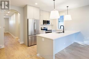 London South (South F) townhouse for rent - A modern kitchen with a stainless steel refrigerator and white countertops.
