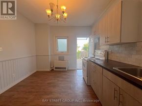 Fort Erie (Central) apartment for rent - A kitchen with wooden floors and a chandelier.