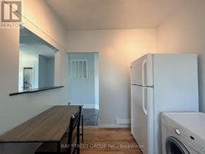 Fort Erie (Central) apartment for rent - A kitchen with a white fridge and a washing machine.