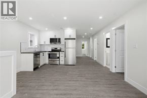 Windsor apartment for rent - A spacious kitchen with white cabinets and a grey floor.