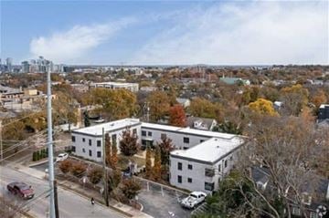 Nashville apartment for rent - A white building with a green roof is surrounded by trees with autumn leaves.