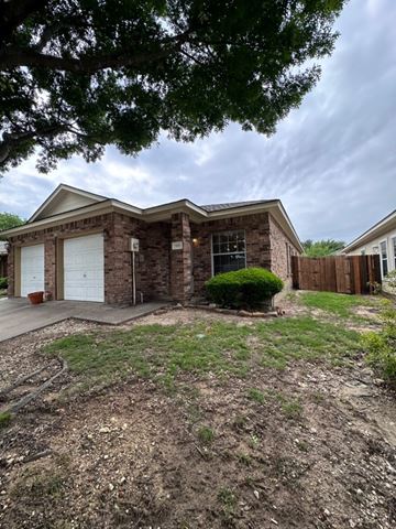 Midlothian apartment for rent - A house with a white garage door is surrounded by a grassy area.
