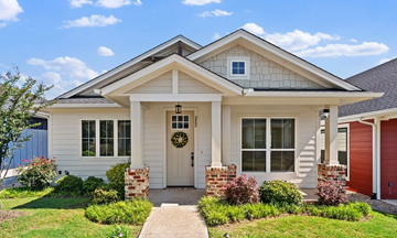 Waxahachie apartment for rent - A white house with a grey roof and a red garage door.