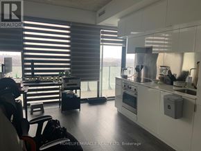 Toronto (Mount Pleasant West) condo for rent - A modern kitchen with white cabinets and a large window with blinds.
