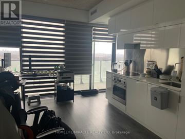 Toronto (Mount Pleasant West) condo for rent - A modern kitchen with white cabinets and a large window with blinds.