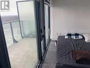 Toronto (Mount Pleasant West) condo for rent - A bedroom with a large bed and a glass door leading to a balcony.