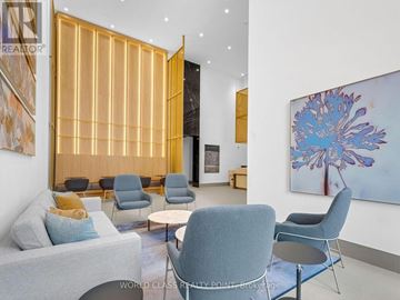 Mississauga (Creditview) condo for rent - A living room with a grey couch, a blue chair and a painting on the wall.