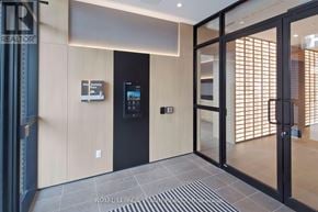 Milton (Cb Cobban) condo for rent - A modern office lobby with a black door and a glass wall.