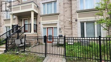 Brampton (Brampton West) townhouse for rent - A brick building with a black fence in front.
