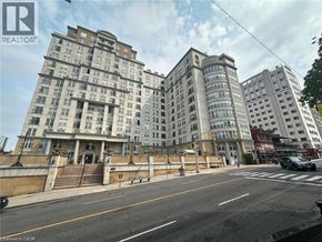Hamilton condo for rent - A street view of a city with buildings and a car on the road.