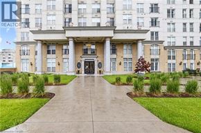Hamilton condo for rent - A building with a large front entrance and a walkway leading to it.